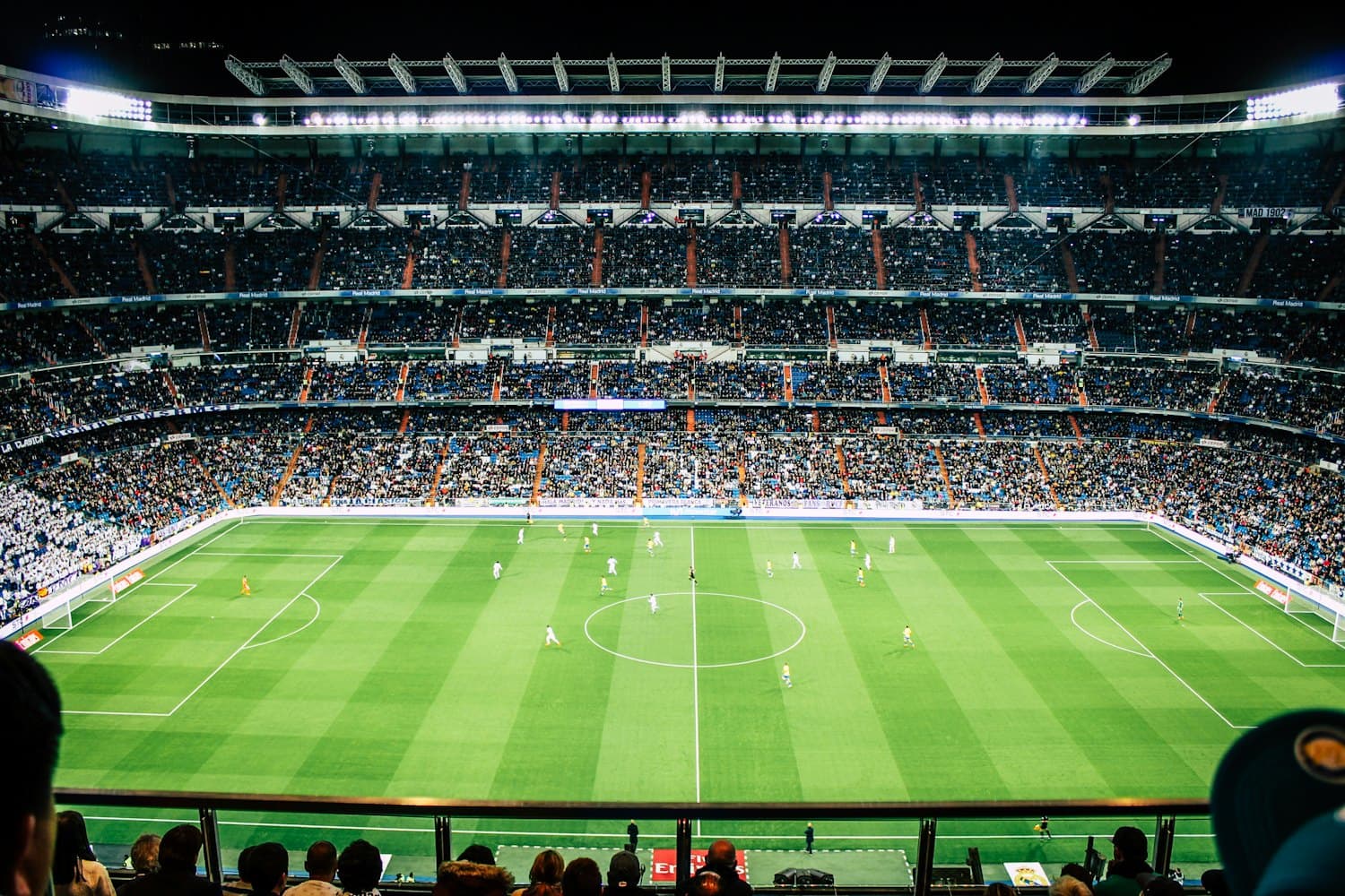 A packed football stadium under floodlights